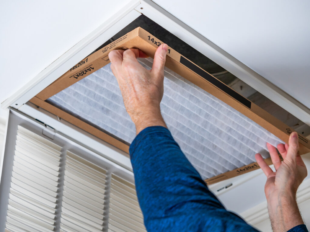 HVAC technician replacing a home air filter in Carmichael