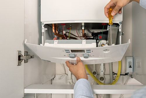Heating technician repairing a residential boiler in Carmichael
