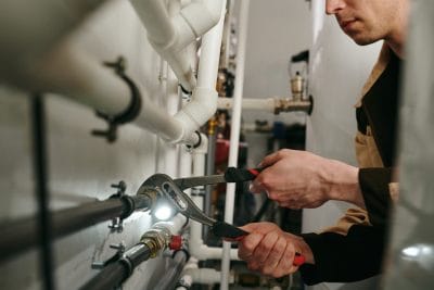 Technician inspecting commercial plumbing pipes in Carmichael