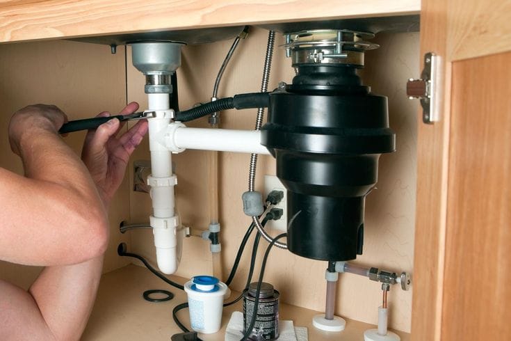 Plumber repairing a garbage disposal in Carmichael