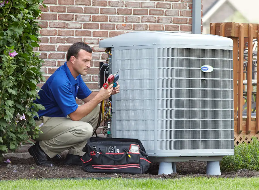 HVAC technician inspecting an outdoor AC unit in Carmichael